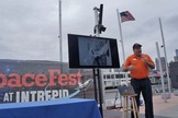 Mark Roberts, a tour guide at the Intrepid Air & Space Museum in New York, gives a talk about going to the bathroom in space on July 25, 2013, during SpaceFest. The picture he is pointing to on the screen shows a NASA engineer modestly demonstrating how an Apollo fecal collection bag works over a pair of plaid pants.