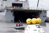 Divers attach tow lines to an Orion test spacecraft during a stationary recovery test at Norfolk Naval Base in August 2013.