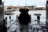 An Orion test spacecraft is silhouetted on the carrier deck after recovery test.