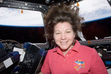 NASA astronaut Cady Coleman is seen inside the Cupola of the International Space Station. Earth's horizon and the blackness of space are visible through the windows.
