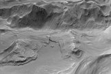This image shows a high-resolution view of layered materials and collapse features on the floor of Eden Patera. The layers represent areas where lava in an ancient lava lake attached to ridges and hills in the floor of the crater, froze against the bedrock, and then detached as the lava lake drained from beneath. Image released Oct. 2, 2013.