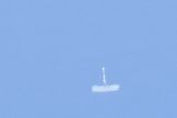 The first stage of SpaceX's Falcon 9 v1.1 rocket comes down to Earth after its maiden launch on Sept. 29, 2013. Engineers managed to re-light the first stage engines twice as part of a reusability test.