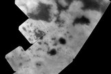 The vast hydrocarbon seas and lakes (dark shapes) near the north pole of Saturn's moon Titan sprawl out beneath the watchful eye of NASA's Cassini spacecraft. Image released Oct. 23, 2013.