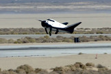 The private Dream Chaser space plane built by Sierra Nevada Corp. is seen landing with its left landing gear not deployed properly in this still from an Oct. 26, 2013 unmanned drop test at Edwards Air Force Base in California. The gear malfunction caused the prototype to skid off the runway.