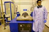 Asha Punnoose beams next to TJ3Sat, a the first CubeSat to be built by high school students and launched into space through NASA's ELaNA program.