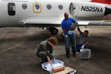 Researcher on NASA's 'bug team' prepare test surfaces to attach to the wings of NASA Langley's HU-25C Falcon aircraft before a flight through the sticky late summer weather in Virginia.