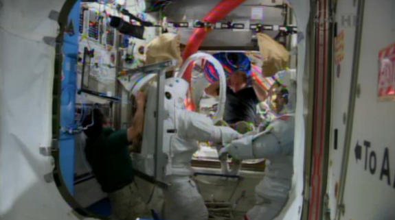 NASA astronauts Rick Mastracchio and Mike Hopkins (in suits) try on their spacesuits inside the International Space Station on Dec. 16, 2013 to prepare for a potential spacewalk repair of the outpost's cooling system.