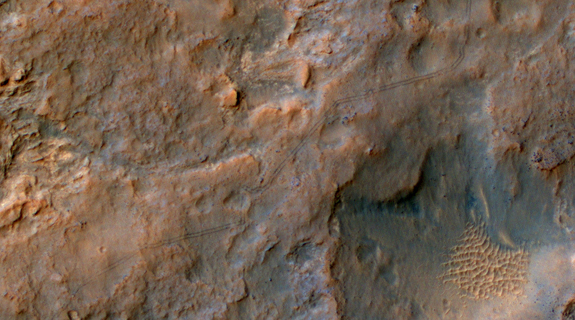 Two parallel tracks left by the- wheels of NASA's Curiosity Mars rover cross rugged ground in this portion of a Dec. 11, 2013, observation by the High Resolution Imaging Science Experiment (HiRISE) camera on NASA's Mars Reconnaissance Orbiter. The rover itself does not appear in this part of the HiRISE observation. Image released Jan. 9, 2014.