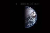 A Sun glint on Earth is captured (center of the black circle) in this image taken by NASA's Deep Impact spacecraft as it looked at the north pole. The reddish area is North America, and the glint is coming from a body of water in California.