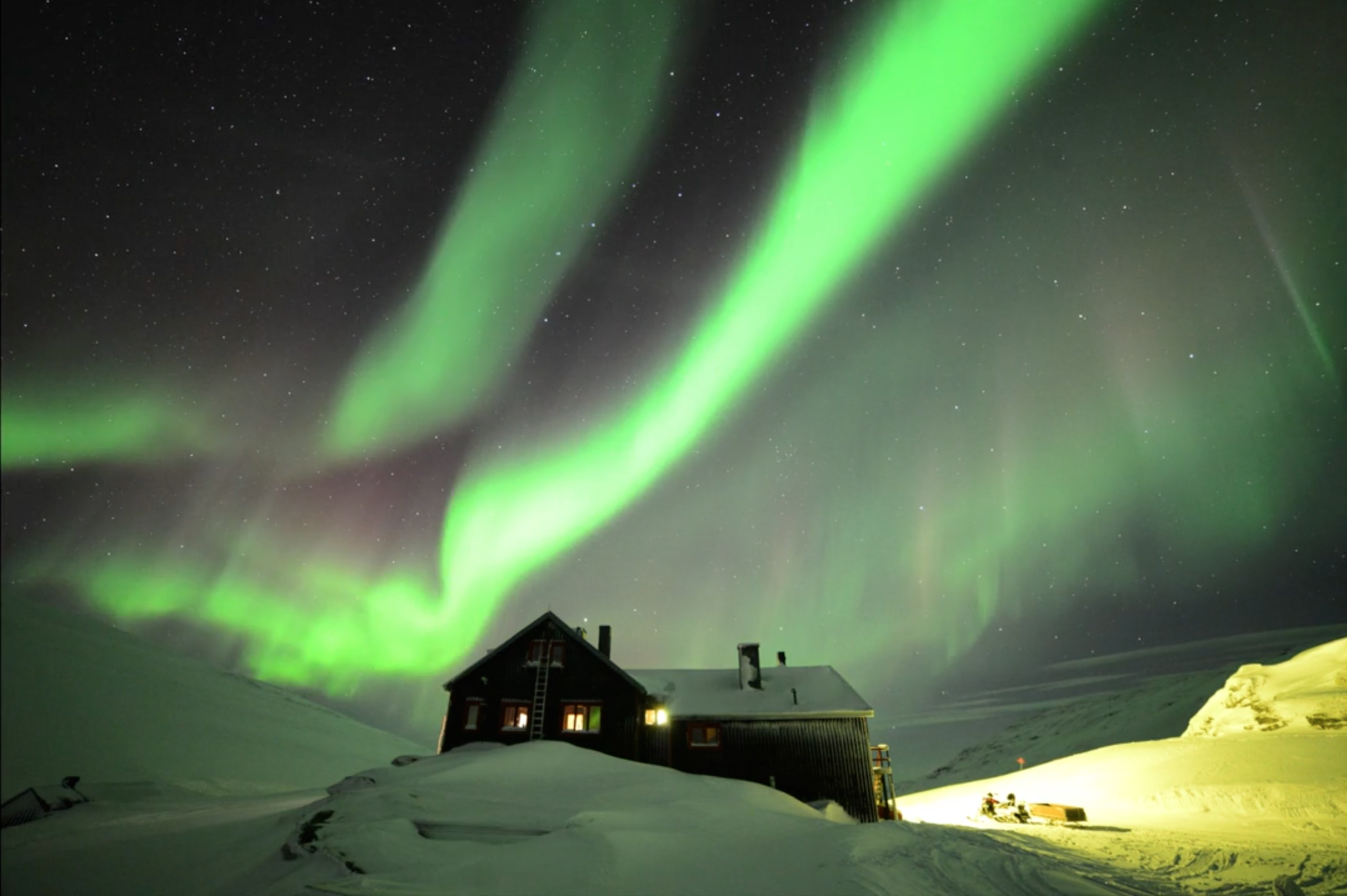 Auroras Glow Over Hotel in Swedish Lapland by Chad Blakley