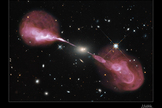 The same physical processes that power microquasars such as MQ1 are also at work in active galaxies and quasars (at much larger scales). Here we can see the same structure (powerful central black hole, jets, lobes) in the active galaxy Hercules A. In both classes of systems, the energy comes from the infall of gas towards the central black hole.