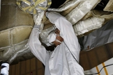 An engineer works on the Parachute Deployment Device of the Low Density Supersonic Decelerator test vehicle in this image taken at the Missile Assembly Building at the US Navy's Pacific Missile Range Facility in Kaua‘i, Hawaii. Image released May 16th, 2014.