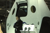 Elon Musk poses with his newest – and most remarkable – achievement, the Dragon Version 2 spacecraft, on May 29, 2014.