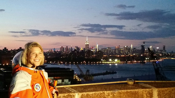 NASTAR space training center director Brienna Henwood, clad in a Final Frontier Design spacesuit, poses for photos with the New York City skyline as a backdrop during Final Frontier Design's Spacesuit Experience launch party on Aug. 28, 2014. The Brooklyn-based Final Frontier Design's Spacesuit Experience allows customers to wear its third-generation spacesuit under pressure, try out golf and a flight simulator, while learning how spacesuits work. The experience costs about $400.