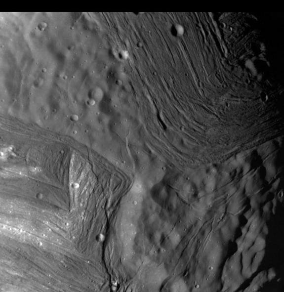 This photo of Uranus' moon Miranda, taken by NASA's Voyager 2 probe in January 1986, shows an unusual "chevron" figure and regions of distinctly differing terrain on the mysterious satellite.