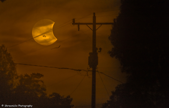 Photographer Shreenivasan Manievannan in South Carolina captured this view of the partial solar eclipse of Oct. 23, 2014 through fog and power lines, revealing an ethereal view of the event and giant sunspots on the sun.