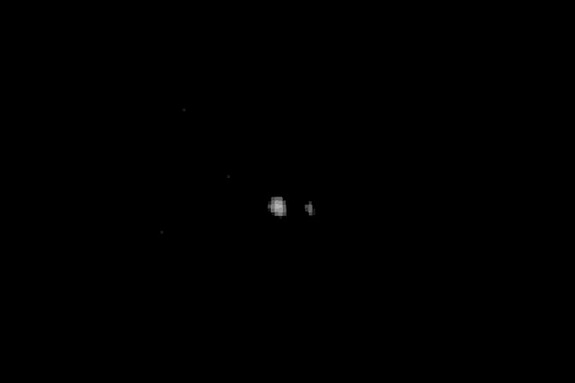 This photo of Pluto (center) and its largest moon Charon was captured by NASA's New Horizons spacecraft in July 2014 and released on Aug. 7. New Horizons took this image and others from a range of 267 million to 262 million miles (429 million to 422 million kilometers).