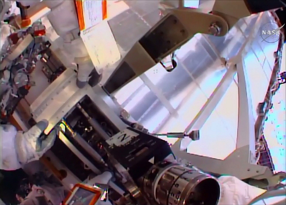 NASA astronauts Scott Kelly and Kjell Lindgren work together to remove a thermal cover on an external ammonia station during their spacewalk Nov. 6.