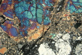 This piece of the moon collected by astronauts on the Apollo 17 lunar landing mission shows a sample of lunar highland rock as viewed in cross-polarized transmitted light.
