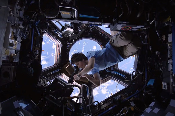 ESA astronaut Samantha Cristoforetti, inside the space station cupola, photographs the Earth in a scene from the IMAX film 