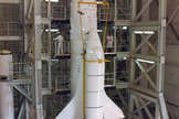 Archival photograph showing the stacking of NASA's quarter-scale space shuttle engineering model for testing. 