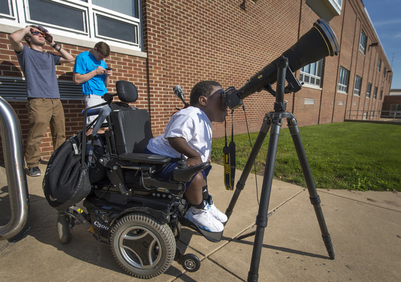 12th class tyro Jay Hallman looks by a photographer's lens and solar filter to see a universe Mercury as it transited opposite a face of a object on Monday, May 9, 2016, in, Boyertown, Pennsylvania.