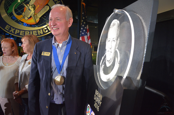 2016 Astronaut Hall of Fame inductee Brian Duffy stands with the plaque that will represent him in the Hall at the Kennedy Space Center Visitor Complex in Florida.