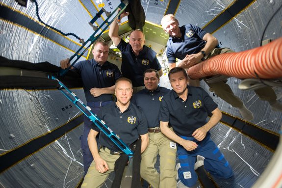 The six space dads of Expedition 47 post for a photo inside the Bigelow Expandable Activity Module on the International Space Station. They are: (top row from left) Alexey Ovchinin or Russia, Jeff Williams of NASA, Tim Peake of the U.K. (Bottom row from left) Tim Kopra of NASA, Oleg Skripochka and Yuri Malenchenko, both of Russia.
