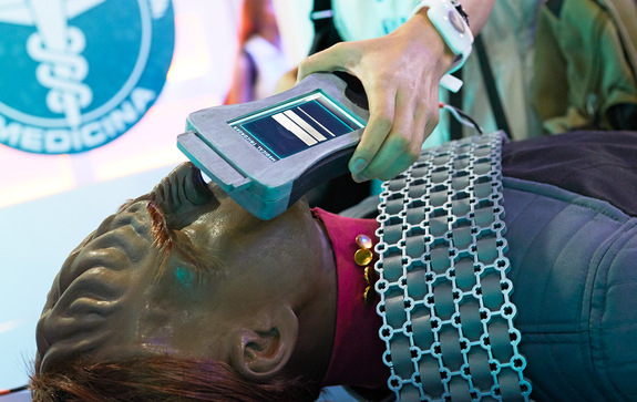 At the medical station, cadets are asked to examine a Klingon patient with a medical tricorder and diagnose the patient's illness accordingly.