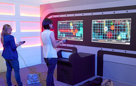 Space.com's Calla Cofield and Samantha Mathewson test their tactical skills by firing a phaser at various moving targets on a screen.