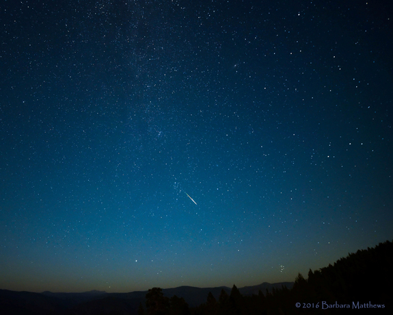 A bright Perseid meteor flashes in a night sky tinged with smoke from nearby forest fires in this view by photographer Barbara Matthews captured from Nevada County, California during the peak of the 2016 Perseid meteor shower on Aug. 11-12.