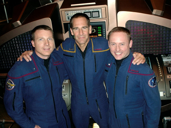 Scott Bakula, who played Captain Jonathan Archer on Star Trek: Enterprise, stands with astronauts Terry Virts and Mike Fincke on set. The two astronauts made guest appearances on the series finale episode “These Are The Voyages …” March 2005.