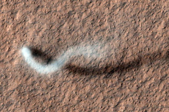 A dust devil snakes across the Martian landscape, kicking dust into the air. 