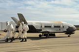 Recovery crewmembers process the X-37B Orbital Test Vehicle at Vandenberg Air Force Base in California after the robotic space plane touched down in October 2014.