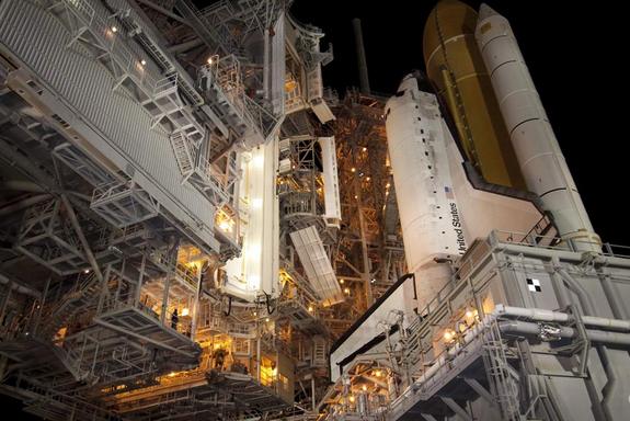 The rotating service structure, which provides weather protection and access to the shuttle, moves into place around space shuttle Discovery on Launch Pad 39A at NASA